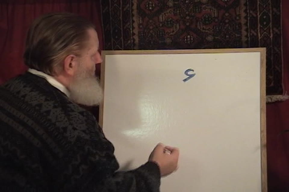 Yusuf Estes writing an Arabic letter on a whiteboard